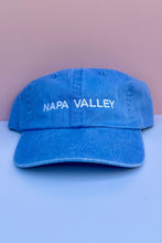 Load image into Gallery viewer, A blue denim baseball cap with 'NAPA VALLEY' embroidered in white across the front.
